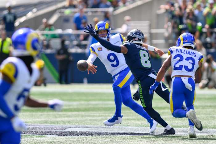 Sep 10, 2023; Seattle, Washington, USA; Los Angeles Rams quarterback Matthew Stafford (9) throws the ball away before being tackled by Seattle Seahawks cornerback Coby Bryant (8) during the first half at Lumen Field. Mandatory Credit: Steven Bisig-USA TODAY Sports